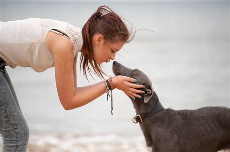 Beautiful Young Girl Kissing her Dog with Love